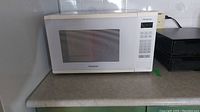 Front view of Panasonic microwave showing overall condition, door with window and handle.