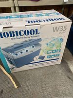 Mobicool W35 cooler box showing product image, branding, 12 volt portable cooler with wheels, capacity details.