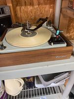 Photo of Garrard turntable showing woodgrain finish and tonearm on platter