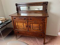 Front view of rustic vintage wooden cabinet showing drawer and door layout, mirror, and wood grain.