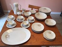 Full lot of Rosenthal Germany Sunburst dinnerware pieces arranged on a table showing cups, saucers, plates, bowls, teapot, sugar bowl, and cream pitcher.