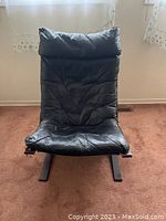 Front view of black leather chair on curved wooden sled frame