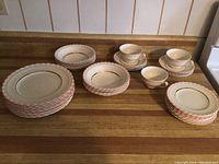 Full set including stacked large serving plates, smaller plates, bowls and cups with visible crazing and fading.