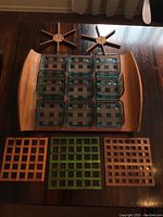 Overall view showing wooden serving tray with nine glass bowls placed inside, three lattice wooden coasters below, and two star-shaped wooden trivets above.