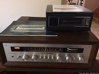 Sony 8-track player and Marantz receiver stacked together with manuals on top