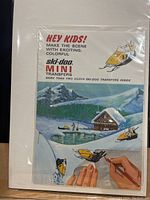 Front cover of the Ski-Doo Mini Transfers booklet showing colorful winter scene and snowmobiles with promotional text.