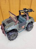 Side perspective of 1993 GI Joe GPV Rhino Jeep with mounted cannon and large rugged tires.