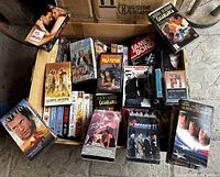 Box with various VHS movies displayed, including titles such as Dirty Dancing, Pulp Fiction, James Bond, Casablanca.