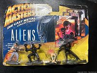 Front view of the original 1994 Action Masters Aliens diecast figures sealed in blister pack with a damaged and creased packaging showing all four figures and promotional insert inside.