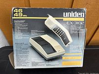 Front side of box showing Uniden EX-3102 cordless phone with handset and base station, frequency info, and product features.