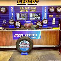Interior photo showing the service counter with Falken Tires branding and tire displays at Expert Tire Auto Truck Certified Service.