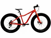 Side view of orange Genesis Mammoth II fat tire bicycle showing frame, tires, drivetrain and brakes