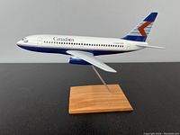Side view of the Canadian Airlines Boeing 737 model airplane mounted on wooden stand showing detailed livery and registration number C-GCDP.