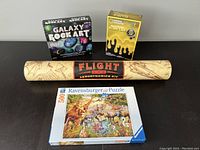 Photo showing all four kits/items together including Galaxy Rock Art, Glow-in-the-Dark Slime Lab, Flight and Aerodynamics Kit, and Ravensburger puzzle