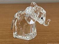 Front-side angle view showing the crystal elephant figurine with metal tail and detailed facets.