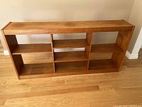 Full front view of the teak shelving unit showing overall structure and shelf layout