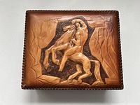 Top view of the handmade leather box showing embossed horse and rider relief on lid with textured background and stitched edges.