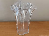 Front and angled views of vintage Muurla hand blown clear glass handkerchief vase with scalloped edges.