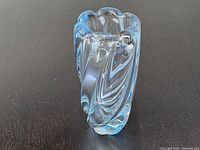 Front and side view of vintage blue Orrefors glass vase showing twisted swirl shape and scalloped rim.