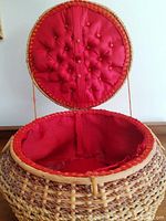 Top view of basket with lid open revealing red padded fabric lining inside.