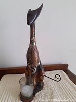 Front angled view showing the cat candle holder with candle glass cup and curled metal tail.