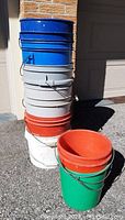 Photo of stacked utility pails showing various colors and metal handles