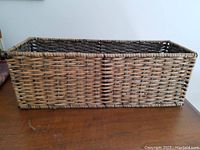 Front and side angled view of rectangular wicker and wire basket showing weave pattern and structure.