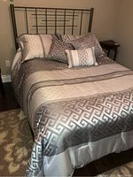 Full view of the double bed made up with bedspread and pillows, showing bed dimensions and set up.