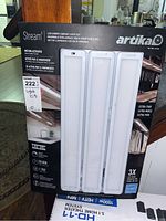 Front of the box showing brand Artika, model Stream, LED under cabinet light kit, with three light panels displayed.