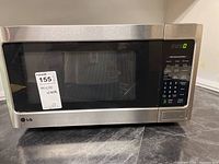 Front view of LG stainless steel microwave with closed door, model LMC1050ST sticker label showing price and identification.