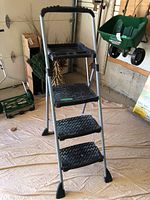 Front angle view of Cosco 4-step aluminum step ladder showing steps and handle