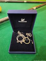 Original Swarovski box containing necklace and earrings set with visible Swarovski logo on inner lid.