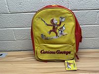 Front view of Curious George backpack showing full design and tag