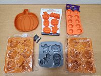 Top-down photo of all six Halloween-themed silicone molds arranged on a flat surface, showcasing pumpkin, ghost, bat, and skull shapes