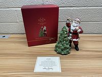 Photo showing Lenox red box, porcelain figure of Santa with decorative Christmas tree, and certificate of authenticity card.