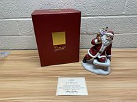 Photo showing the Lenox figurine box, certificate of authenticity, and the Santa Claus figurine.