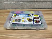 Clear plastic organizer kit with label showing contents: 4000 loom bands, 200 hook bands, 100 clips, stickers for personalization.