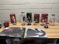 View of the Arizona Diamondbacks collectibles lot showing 3 bobblehead player figures, piggy bank, glass milk bottle, puzzles, and memorabilia cards.