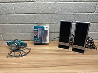 Lot includes two pairs of desktop computer speakers and one pair of turquoise wired headphones, with Logitech V10 speakers in original box.