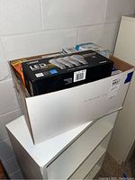 Box containing various lightbulbs including LED and CFL types