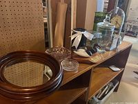 Overview of items on wooden shelves including mirror, ashtrays, vases, clock, and decorative items