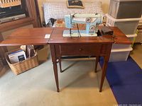 Full view of Sewcraft sewing machine on wooden table with side leaves extended