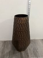 Front view of the vase showing full height and pattern with measuring tape behind indicating about 23 inches tall.