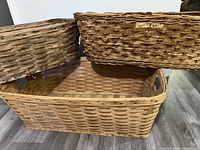 Photo showing all three vintage wicker baskets stacked, highlighting size and color differences