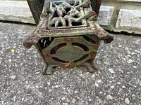 Close-up of the bottom side of the cast iron lantern showing the cutout design and the aged patina