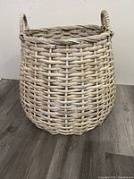 Side and angled view of large woven basket planter with white finish showing weave pattern and handles.