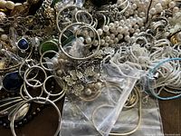 Mixed jewelry assortment with pearl-like and metal pieces close-up