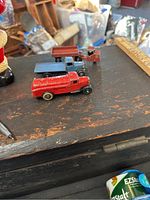 Three vintage Dinky Toys trucks positioned on a wooden surface showing overall view