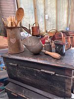 Wide view showing all items including tin pitcher with heart mark, scoop with wooden handle, creamer, wooden utensils, and figurine.