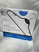 Box of Mainstays brand 50-Pack Felt Suit Hangers with depiction of the hanger style and product details on the packaging.